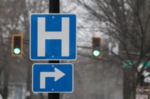 A blue sign with a white "H" indicating there is a hospital on the next turn.