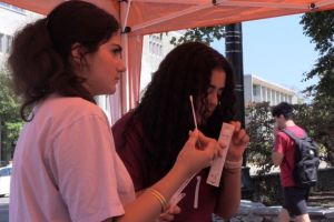 Two students sit at a table and answer math problems.