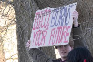 A protest sign at Sunrise Bloomington's rally to demand Indiana University to divest from fossil fuels.