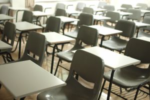 classroom full of rows of empty gray school desks