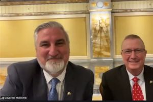 Jeff Thompson and Travis Holdman speak to each other while seated in a committee room