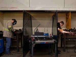 students are welding with helmets on