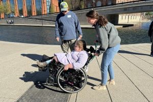Occupational therapist and Skills on Wheels volunteer Maria Fuchs guides 12-year-old Savannah Healton through some wheelchair skills. Savannah's parents, Matthew White and Chanda Healton, observe and learn to be able to help her as she practices.