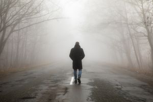 Man walking away in foggy rain