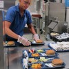 In this 2012 photo, a cafeteria worker prepares lunch trays for first grade students. (Elle Moxley/StateImpact Indiana)