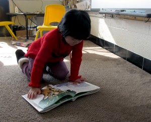 A student at Busy Bees Academy, a public preschool in Columbus, Ind., reads before nap time.