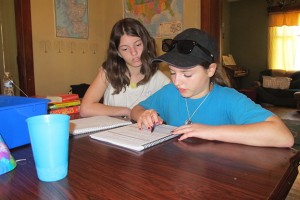 Emily (left) and Holli Burnfield work on language arts lessons together. The girls are homeschooled, along with their younger sister Layla, in Bloomfield.