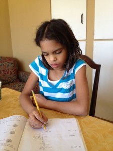 Fourth grader Isa Ruegger completes a page in her workbook at home. (Photo Credit: MaryAnn Schlegel Ruegger)