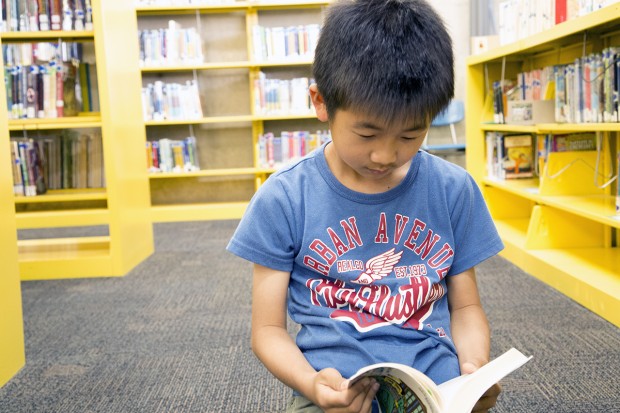 Nine-year-old Yoki Murabayashi reads a book in Japanese, his native language. 