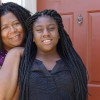 LaToya Tahirou stands behind her daughter Lamya Hale at their Carriage House East apartment. Lamya will enter the sixth grade at PLA @ 103 in August. She likes the school because “teachers are close to you, and they love you.” (Photo by Eric Weddle, WFYI)