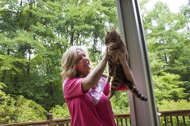 Brandy Hauser plays with her cat on the porch of her Spencer, IN home. She says the rural location of her home has made getting services for her daughter difficult. (Peter Balonon-Rosen/Indiana Public Broadcasting)